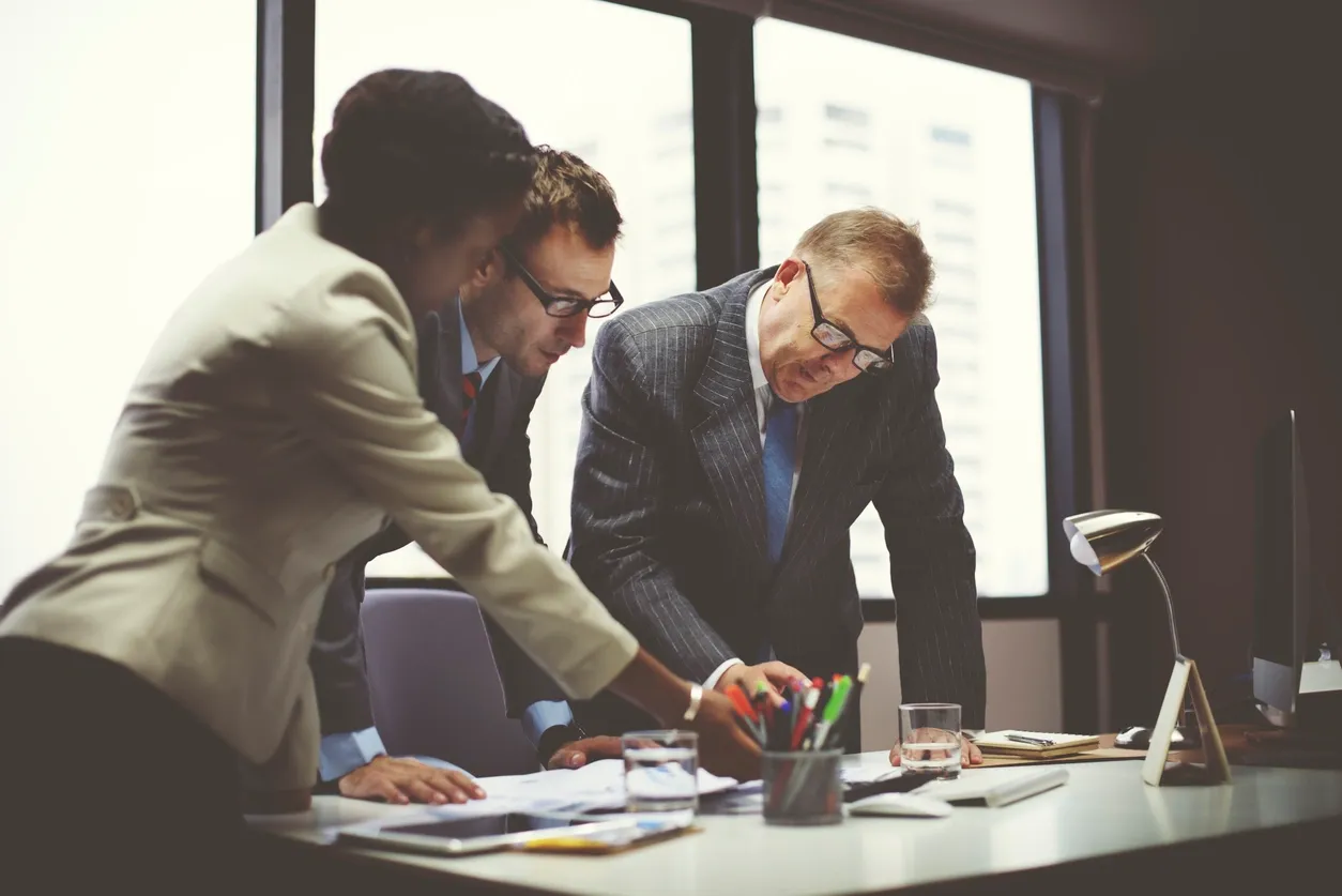 Business team collaborating over documents in office